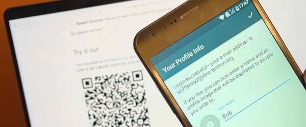 گوشی بعد از ورود نشانی نمایه را نشان می‌دهد و روی لپ‌تاپ یک QR باز است